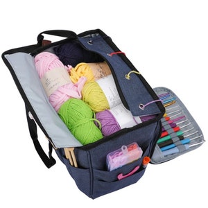 May include: A blue canvas knitting bag with multiple pockets and compartments. The bag is filled with colorful yarn balls and knitting needles.
