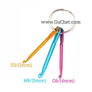 May include: A set of three colorful crochet hooks attached to a silver key ring. The hooks are orange, blue, and pink and are labeled with their sizes: D3/3mm, H8/5mm, and G6/4mm. www.GuChet.com