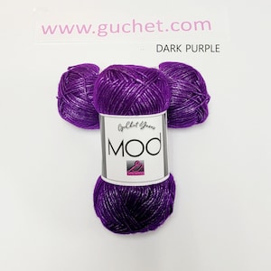 May include: Three skeins of dark purple yarn with a metallic sheen, arranged in a cluster. A white paper label wraps around the center, featuring the text Guchet Yarns, MOD, and the website www.guchet.com with the color label DARK PURPLE.