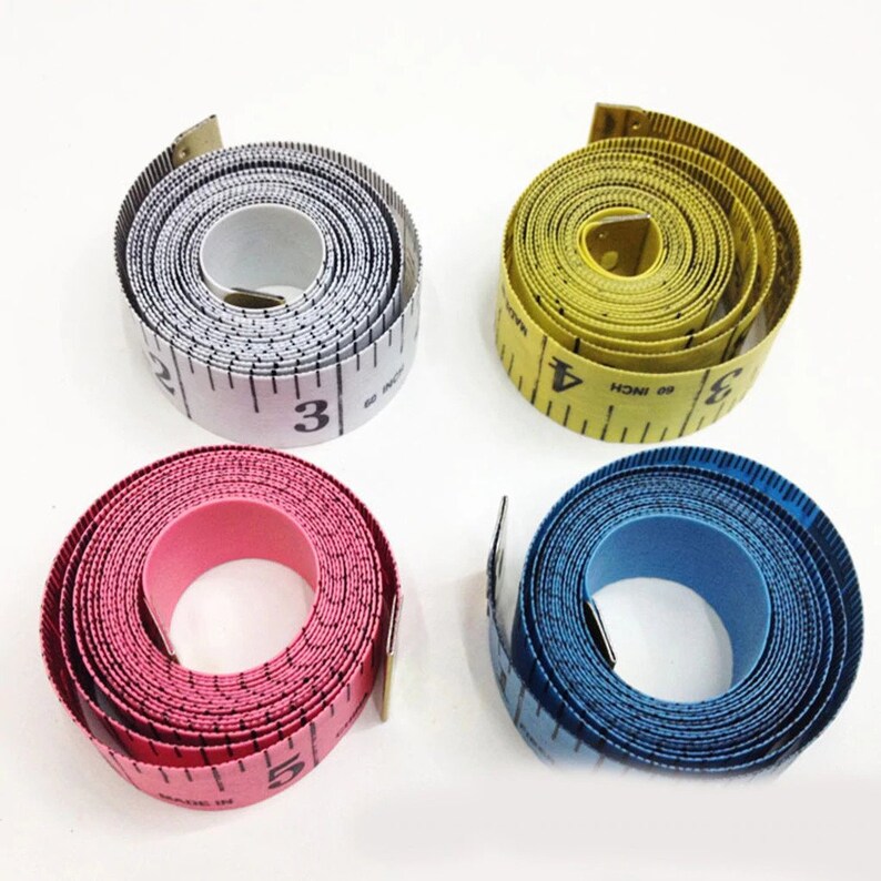 May include: Four different colored measuring tapes, each rolled up and ready to use. The tapes are white, yellow, pink, and blue.