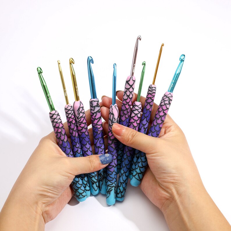 May include: A set of 10 colorful crochet hooks with mermaid scale-patterned handles. The hooks are made of metal and have a variety of sizes.