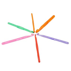 Pu&ograve; includere: Un set di sei uncinetti di plastica colorati disposti a forma di stella su uno sfondo bianco. Gli uncinetti sono arancioni, verdi, rosa e viola.