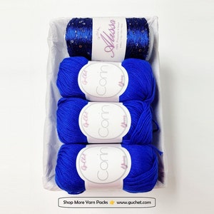 May include: A set of three blue yarn skeins and a spool of blue and silver glitter yarn in a white gift box. The yarn skeins are labeled "Corn" and the glitter yarn is labeled "Aussa". The box has the text "Shop More Yarn Packs www.guchet.com" printed on the bottom.
