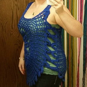 May include: A blue crocheted top with a loose, open weave. The top has a scoop neck and a sleeveless design. The top is worn over a green tank top.