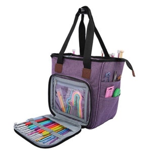 May include: Purple tote bag with multiple pockets and a zippered compartment for storing knitting needles. The bag has a black handle and a clear plastic window on the front.
