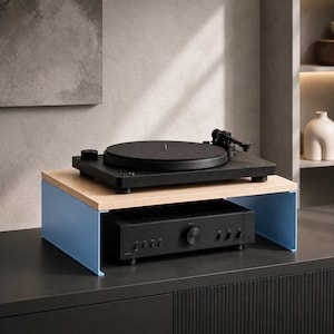 May include: A light blue metal stand with a light wood top surface. A black turntable sits on the top of the stand, while a black audio amplifier with multiple knobs and a central volume dial is positioned underneath the wooden shelf.