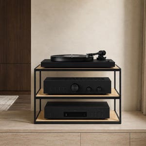 May include: A three-tier audio equipment stand featuring a black metal frame and light wood shelves. The top shelf holds a black turntable, while the middle and bottom shelves house black electronic components with circular knobs and buttons.