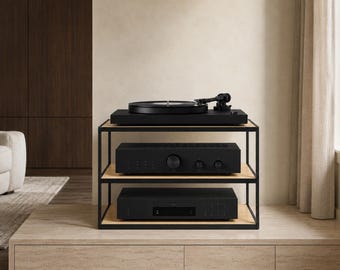 May include: A three-tier audio equipment stand featuring a black metal frame and light wood shelves. The top shelf holds a black turntable, while the middle and bottom shelves house black electronic components with circular knobs and buttons.