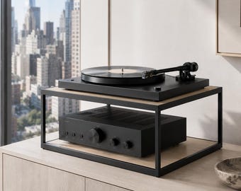 May include: A black turntable with a vinyl record sits on the top shelf of a two-tier black metal and light wood stand. A black audio amplifier with multiple circular control knobs is positioned on the bottom shelf of the same metal stand.