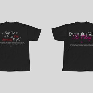 May include: Two black t-shirts with different inspirational quotes printed on the back. The left shirt says "Keep the Inner Fire Burning Bright" in white and red text. The right shirt says "Everything Will Be Okay" in white and pink text.