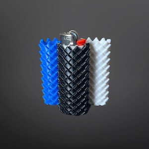 以下が含まれることがあります： 青、黒、白の3Dプリントされたライターカバー3つ。各カバーは、テクスチャードダイヤモンドパターンです。