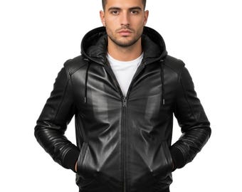 May include: A black leather jacket with a hood and a zipper closure. The jacket has a ribbed hem and cuffs, and two front pockets. The person is wearing a white t-shirt underneath the jacket.