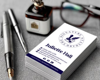 May include: A stack of white business cards with navy blue text and a logo. The cards feature the name "Juliette Hall" and contact information. A silver pen, a fountain pen, and an inkwell with a decorative top are in the background.