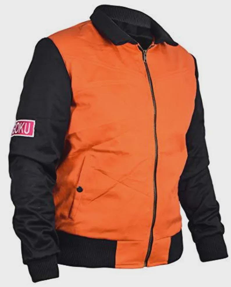 May include: Orange and black bomber jacket with a full-length zipper. The jacket has black sleeves and a black collar and waistband. A small patch with the text "GOKU" is on the left sleeve. The jacket is made of a smooth, possibly nylon, material.