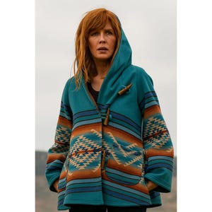 May include: A teal hooded coat with a Southwestern-inspired pattern in shades of brown, orange, and blue. The coat features wooden toggle closures and a hood. The design includes geometric and striped patterns.