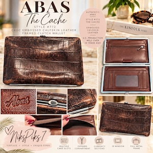 May include: A brown croc-embossed calfskin leather framed clutch wallet labeled ABAS The Cache Style #772. The wallet features a full metal frame, a zippered compartment, multiple card slots, and an ID window. The exterior has a textured finish.