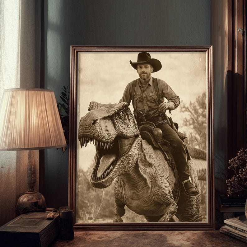 Op de afbeelding: Sepia-getinte ingelijste prent met een cowboy die op een Tyrannosaurus Rex rijdt. De cowboy draagt een hoed, een overhemd en een broek en zit op een zadel. De dinosaurus heeft zijn mond open. De prent wordt aan een muur naast een lamp getoond.