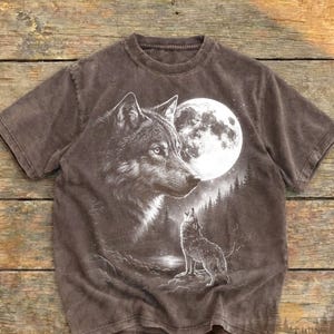 Op de afbeelding: Espresso-kleurig T-shirt met een gedetailleerde afbeelding van een wolf en een volle maan. Een tweede wolf huilt naar de maan. Het shirt heeft een vintage design, met de tekst "Worn Heritage" en "espresso" zichtbaar.