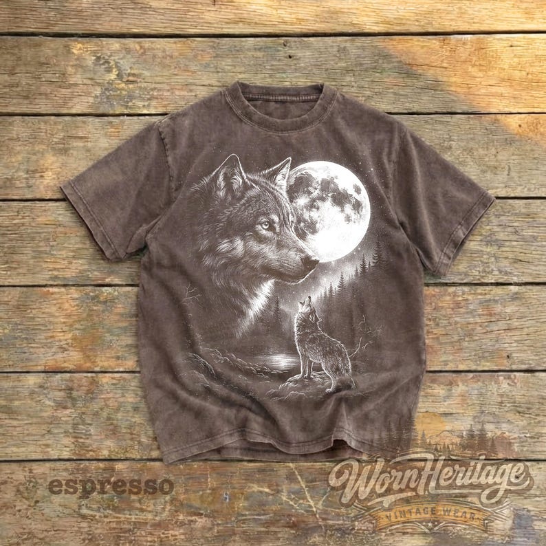 Op de afbeelding: Espresso-kleurig T-shirt met een gedetailleerde afbeelding van een wolf en een volle maan. Een tweede wolf huilt naar de maan. Het shirt heeft een vintage design, met de tekst "Worn Heritage" en "espresso" zichtbaar.