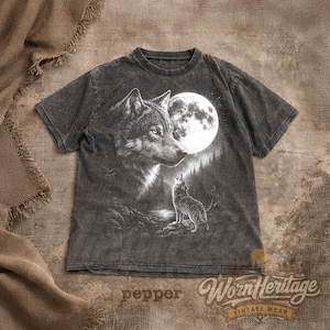 Op de afbeelding: Donkergrijze t-shirt met een wolf en maan afbeelding. Het ontwerp toont een wolvenkop, een volle maan en een huilende wolf in een bos. De t-shirt heeft de tekst "Worn Heritage Vintage Wear".