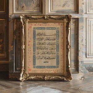 Può includere: Opera d'arte con cornice dorata ornata con calligrafia araba. L'opera d'arte ha uno sfondo color crema con motivi floreali e geometrici in blu, rosa e oro. La cornice è dettagliata con intagli intricati.