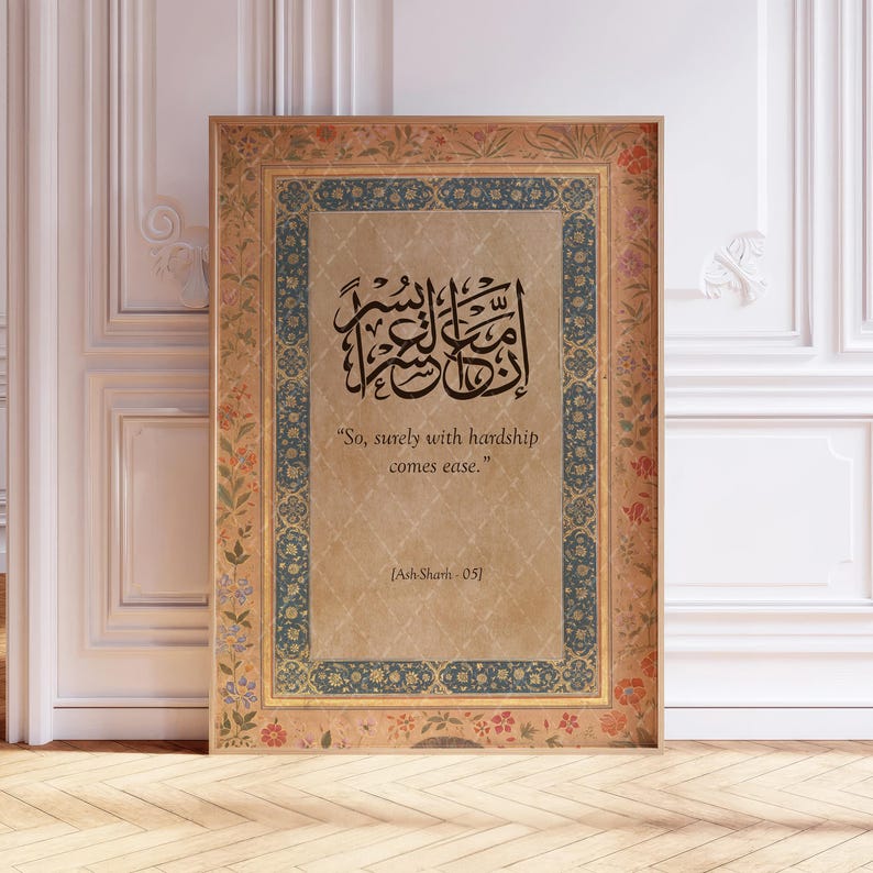 May include: A framed print featuring Arabic calligraphy in black ink on a parchment-toned background. The frame has a decorative border with floral and geometric patterns in shades of gold, blue, and red. The text reads, "So, surely with hardship comes ease."