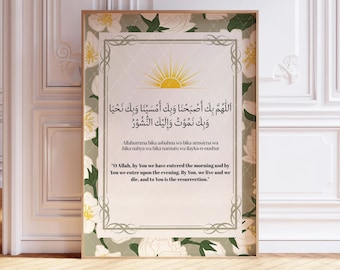 May include: A framed print with Arabic script and English translation. The artwork features a central text with a sun illustration, framed by a floral border in white and green. The frame is a warm brown colour.