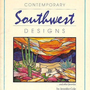 May include: A book cover titled "Contemporary Southwest Designs" with a colorful illustration of a desert landscape. The image features a saguaro cactus, mountains, and a vibrant sunset. The author's name is Jennifer Cole.