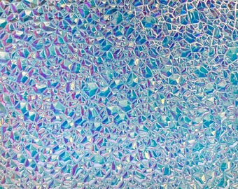 May include: Close-up of a textured surface with a mosaic-like pattern. The surface is a mix of blue, turquoise, and purple hues, creating a shimmering, iridescent effect. The geometric design is composed of irregular shapes.