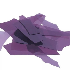May include: A pile of purple confetti, made of thin, translucent paper, in various shapes and sizes.