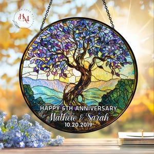 May include: A round stained glass window featuring a tree with purple and blue leaves, a brown trunk, and a yellow and blue background. The text "Happy 6th Anniversary" and names "Matthew & Sarah" with the date "10.20.2019" are displayed.