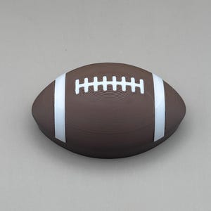 May include: A brown football with white stripes and laces. The football is oval-shaped and has a textured surface. The white stripes run along the sides, and the white laces are in the center.