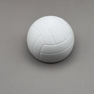 May include: A white volleyball with a textured surface. The ball has a classic panel design with curved seams. The ball is a solid color and appears to be made of a durable material.