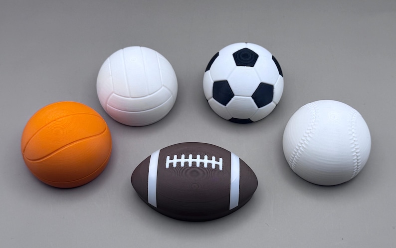 May include: An assortment of sports balls, including a basketball, volleyball, soccer ball, baseball, and football. The basketball is orange, the volleyball and baseball are white, the soccer ball is black and white, and the football is brown with white stripes.