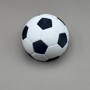 May include: A white and black soccer ball with a classic pentagon and hexagon pattern. The ball is a sphere, with black pentagons and white hexagons. The ball is a sports item.