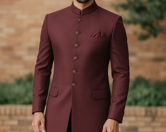 May include: A burgundy long coat with a mandarin collar and a row of buttons down the front. The coat has a pocket on the chest and two pockets at the waist. The coat is worn over black pants.