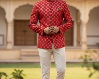 May include: A red jacket with a gold geometric pattern, paired with cream-colored pants. The jacket has a mandarin collar and gold buttons. The outfit is completed with brown leather shoes. The ensemble is suitable for formal occasions.