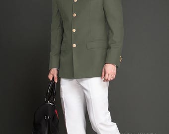 Puede incluir: Chaqueta verde oliva con botones dorados, pañuelo de bolsillo rojo y pantalones blancos. La chaqueta tiene cuello mandarín y se combina con una bolsa de lona negra. El texto "FASHION KURTA" es visible.