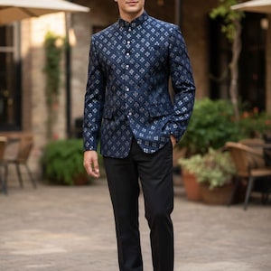 May include: A navy blue patterned jacket with a mandarin collar and button closure, worn with black trousers and brown leather shoes. The jacket has a repeating geometric design in a lighter shade of blue.