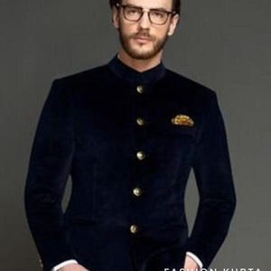 May include: A navy blue velvet jacket with a mandarin collar and gold buttons. The jacket has a pocket square and is paired with white pants. The text "FASHION KURTA" is visible at the bottom right.