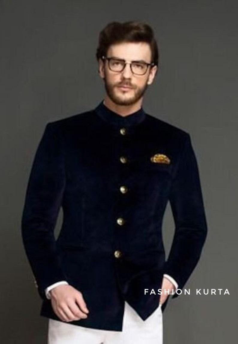May include: A navy blue velvet jacket with a mandarin collar and gold buttons. The jacket has a pocket square and is paired with white pants. The text "FASHION KURTA" is visible at the bottom right.