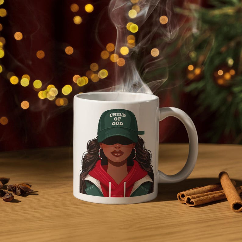 May include: White ceramic mug featuring an illustration of a person wearing a green cap with the text "CHILD OF GOD". The person is wearing a red hoodie and hoop earrings. Steam rises from the mug, suggesting a hot beverage.