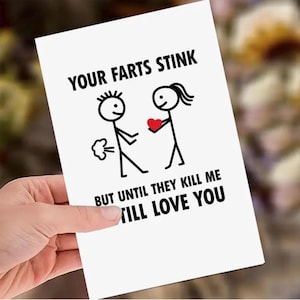 Puede incluir: Una tarjeta de felicitación blanca con texto negro e ilustraciones de figuras de palo. El texto dice: "TUS PEDOS APESTAN PERO HASTA QUE ME MATEN, TE AMARÉ". Una figura de palo emite una nube de pedo, y la otra sostiene un corazón rojo.