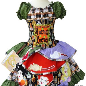 May include: A multi-colored Halloween dress with a black bodice featuring a print of potion bottles and the text "It's all just a bunch of Hocus Pocus". The skirt is layered with green, red, and purple fabric and features embroidered images of the Sanderson sisters from the movie Hocus Pocus.