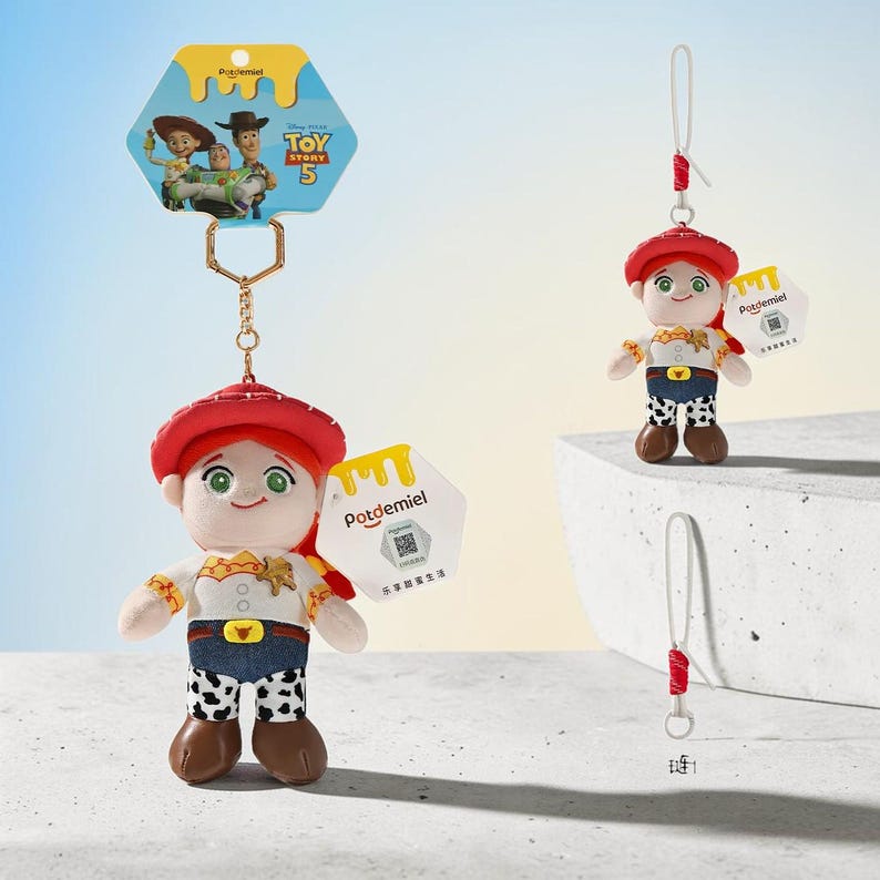 Puede incluir: Un llavero de peluche de Jessie de Toy Story 5, con sombrero rojo, camisa blanca con detalles amarillos, pantalones azules y chaparreras con estampado de vaca. Incluye una cadena de metal dorado, una etiqueta Potdemiel y una tarjeta de Toy Story 5.