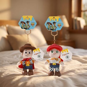 Puede incluir: Dos llaveros de peluche con Woody y Jessie de Toy Story 5. Cada personaje tiene una cadena dorada, una tarjeta de respaldo hexagonal con el logo de Toy Story 5 y una etiqueta hexagonal blanca con la marca Potdemiel y un c&oacute;digo QR.