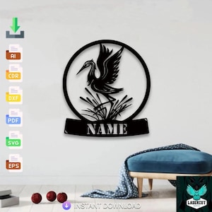 May include: Black metal wall art depicting a crane silhouette inside a circular frame. The crane stands in tall grass, with the word "NAME" below. Suitable for indoor or outdoor decoration.