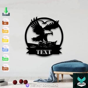 May include: Black metal eagle wall art with outstretched wings, perched on a rock, inside a circular frame. The word "TEXT" is displayed on a banner below the eagle. Two birds are flying above the eagle.