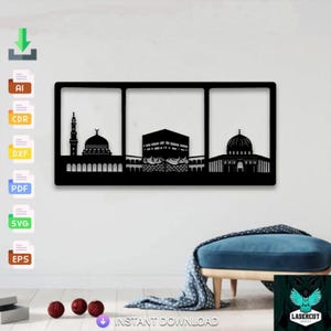 Pode incluir: Arte de parede em metal preto com silhuetas de marcos islâmicos, incluindo uma mesquita com um minarete, a Kaaba e outra mesquita com uma cúpula. A obra de arte é emoldurada e montada numa parede branca.
