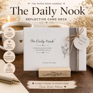 May include: A white card deck titled "The Daily Nook" with a wooden stand, tied with twine. The deck includes 7 guided reflection cards and is designed for quiet moments. The text "A daily pause in paper form" is also visible.